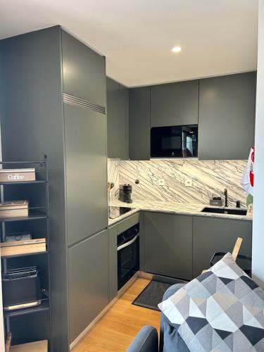 a kitchen with gray cabinets and a counter top at New apartment with large terrace in Matosinhos in Matosinhos