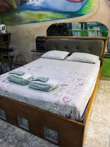 a bed with two mattresses on it in front of a painting at Las mil y una noches in Punta Arenas