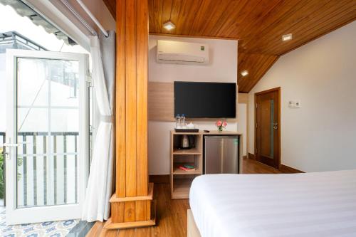 a bedroom with a bed and a flat screen tv at Truc Loc Villa in Hoi An