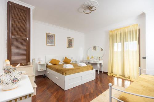 a white room with a bed and a mirror at Villa Maria Pia in Aranova