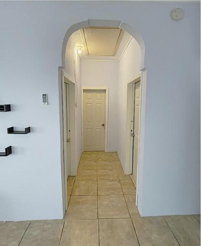 an empty hallway with a white wall and a door at Close to Beach-Perfect Location in Puerto Cortes