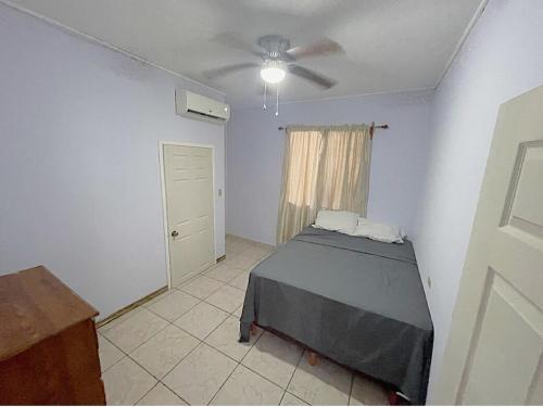 a bedroom with a bed and a ceiling fan at Close to Beach-Perfect Location in Puerto Cortes