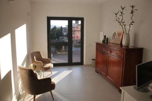 a living room with two chairs and a sliding glass door at B&B Il Melograno in Valmontone