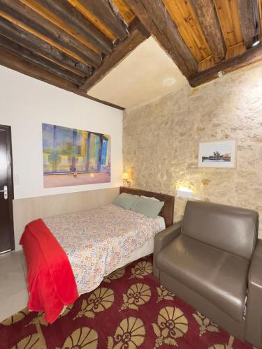 une chambre avec un lit et une chaise dedans dans l'établissement Charles V Flat Ground Floor, à Paris