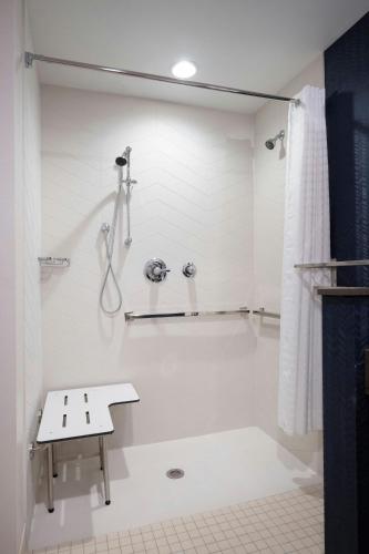 a bathroom with a shower with a bench in it at Fairfield Inn & Suites Arkadelphia in Arkadelphia