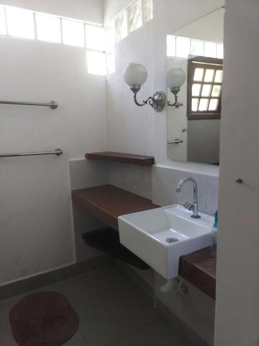 a bathroom with a sink and a mirror at Casa CANTIN DO ACONCHEGO na Praia de Taperapuan, Porto Seguro in Porto Seguro