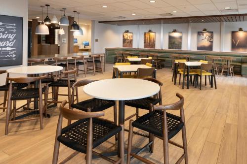 a restaurant with tables and chairs and a bar at Fairfield Inn & Suites Arkadelphia in Arkadelphia