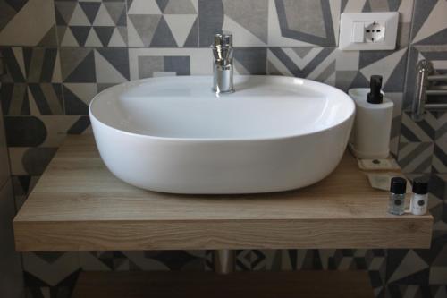 a white sink on a wooden shelf in a bathroom at B&B Il Melograno in Valmontone