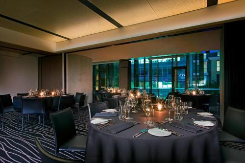 a dining room with tables and chairs with lights at Four Points by Sheraton Brisbane in Brisbane
