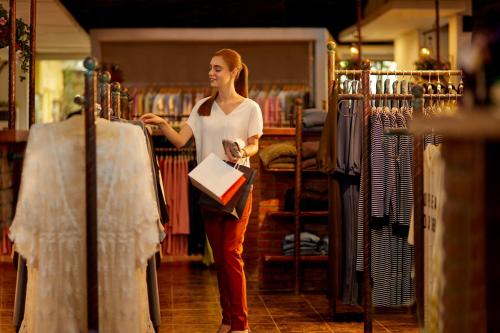 a woman standing in a store looking at clothes at Four Points by Sheraton Bandung in Bandung