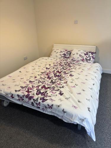 a bed with a white comforter with flowers on it at Jubilee Works in Chesterfield