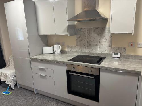 a kitchen with white cabinets and a stove top oven at Jubilee Works in Chesterfield
