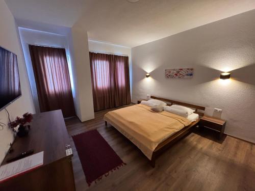 a bedroom with a large bed and two windows at Casa Leone Hotel&Restaurant in Popova Shapka