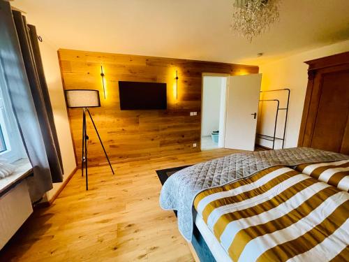 a bedroom with a bed and a flat screen tv at Ferienhaus Greta in Mastershausen