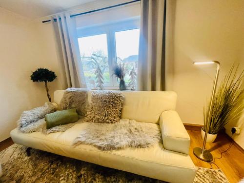 a white couch in a living room with a window at Ferienhaus Greta in Mastershausen