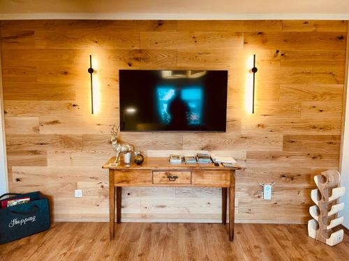 a room with a wooden wall with a television on it at Ferienhaus Greta in Mastershausen