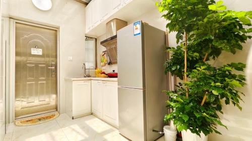 eine Küche mit einem Kühlschrank und einer Topfpflanze in der Unterkunft Shanghai Hills & Aromahome Modern Cottage Home Retreat with 2Bedrooms close to Tianzifang in Shanghai