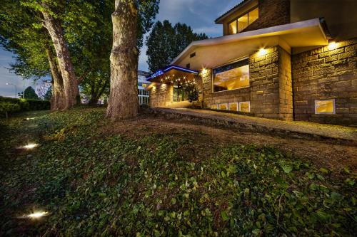 uma casa com árvores na frente em Grão Vasco - Historic Hotel and SPA em Viseu