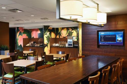 a restaurant with a large wooden table and chairs at Fairfield Inn & Suites by Marriott Omaha West in Omaha