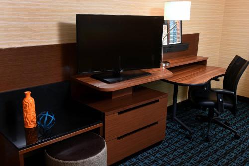 a desk with a monitor and a desk with a chair at Fairfield Inn & Suites by Marriott Omaha West in Omaha