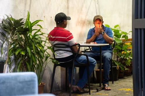two men sitting at a table in a courtyard at The Park House in Male City