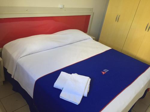 a hotel room with a bed with a towel on it at Hotel Rota do Pantanal in Presidente Prudente