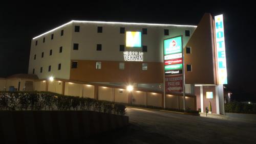 a building with neon signs in front of it at night at Hotel Yekkan in Huauchinango