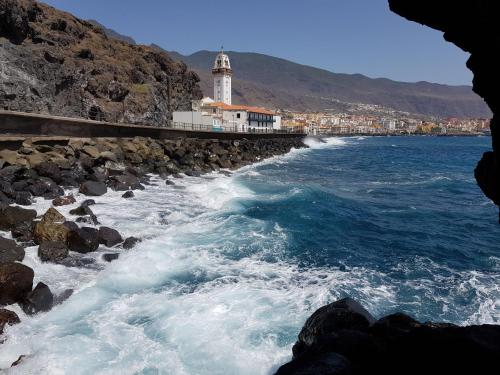 a body of water with a lighthouse in the background at The Magic Dragonfly in Santa Cruz de Tenerife