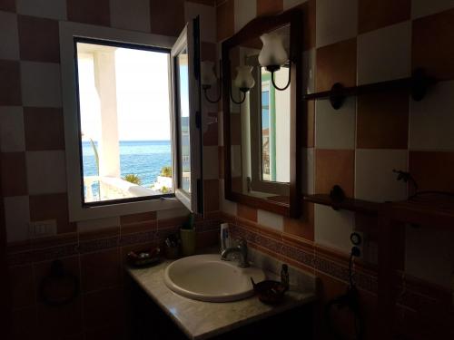 a bathroom with a sink and a mirror and a window at The Magic Dragonfly in Santa Cruz de Tenerife