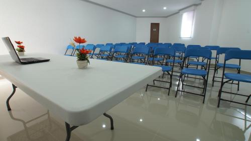 a room with a white table and blue chairs at Hotel Yekkan in Huauchinango