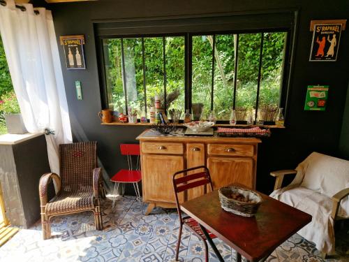 un salon avec une table et une fenêtre dans l'établissement Villa Vallombreuse, à Saint-Alvère