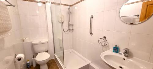 ein weißes Badezimmer mit Toilette und Waschbecken in der Unterkunft Sand Bay, Perranporth in Perranporth