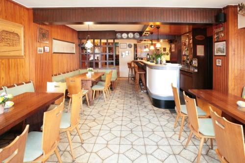 a restaurant with tables and chairs and a bar at Hotel Haus Mühlbach in Nideggen
