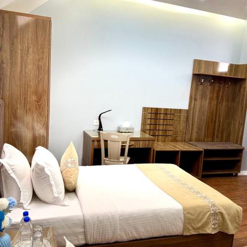 a bedroom with a large bed and a table at Khujand Deluxe Hotel in Khujand