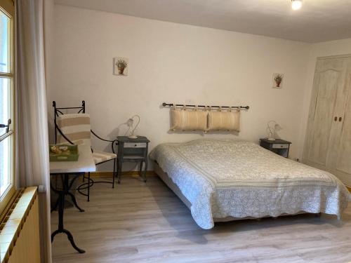 une chambre avec un lit, une table et une chaise dans l'établissement Domaine De La Provenç'âne, à Salernes
