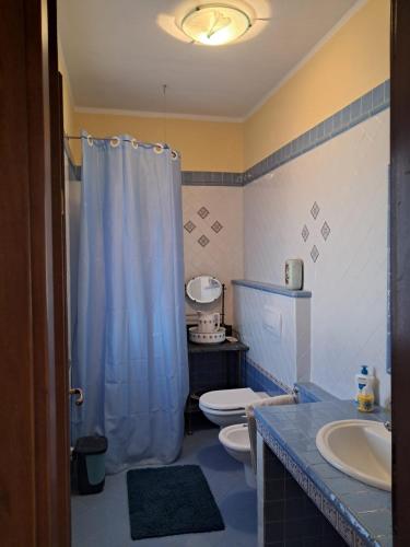 CantaranaにあるCascina Argoのバスルーム(青いシャワーカーテン、トイレ付)