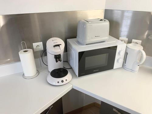 a kitchen counter with a microwave and a coffee maker at Appartement proche gare in Sélestat