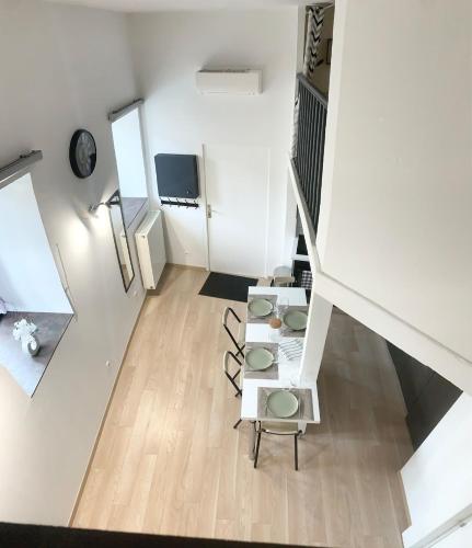 Cette chambre est dotée de murs blancs et d'un escalier avec des chaises. dans l'établissement Appartement proche gare, à Sélestat