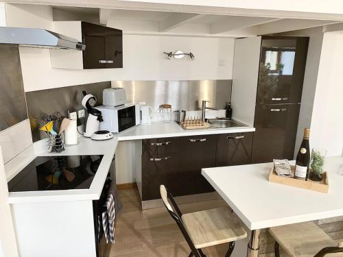 a small kitchen with a white counter and a sink at Appartement proche gare in Sélestat