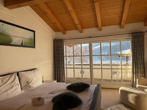 two people sitting on a bed in a room with a window at Villa Kitzbühel in Kirchberg in Tirol