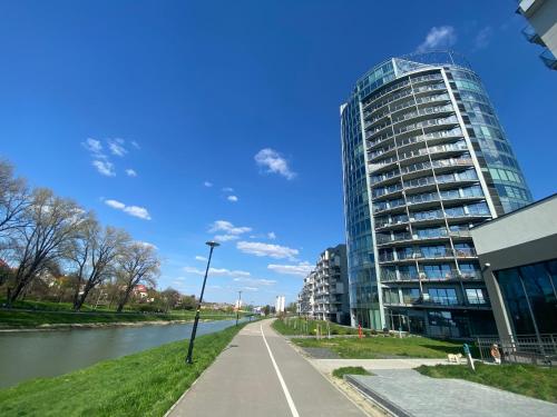 un edificio di alto vetro vicino a un fiume di Apartament Voir a Rzeszów