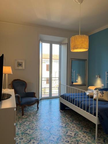 een slaapkamer met een bed en een stoel bij Elisabeth Suite Apartment in Terracina