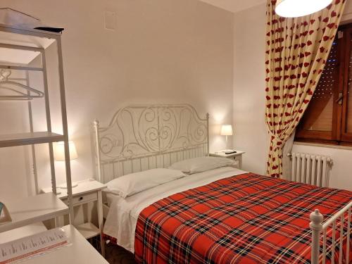 a bedroom with a bed with a red plaid blanket at B&B Da Nonna Lucia in Roccascalegna