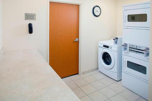 a kitchen with a washing machine and a wooden door at Fairfield Inn & Suites Twentynine Palms - Joshua Tree National Park in Twentynine Palms