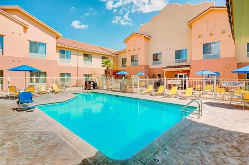 a pool at a hotel with chairs and umbrellas at Fairfield Inn & Suites Twentynine Palms - Joshua Tree National Park in Twentynine Palms