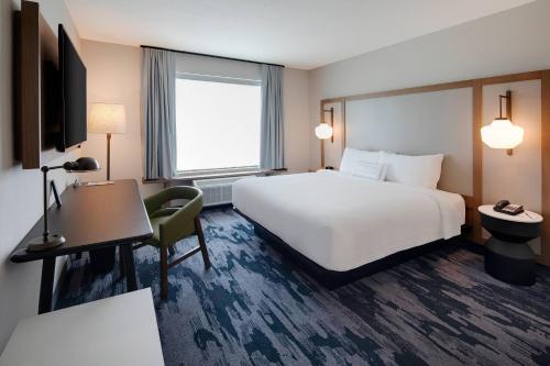 a hotel room with a white bed and a desk at Fairfield Inn & Suites by Marriott Tampa Wesley Chapel in Wesley Chapel