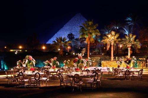 a group of tables and chairs in front of the pyramids at Marriott Mena House, Cairo in Cairo