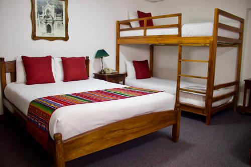 a bedroom with two bunk beds and a ladder at Aleros Hotel Boutique in Cuenca