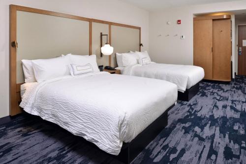two beds in a hotel room with white sheets at Fairfield Inn & Suites by Marriott Canton in Canton