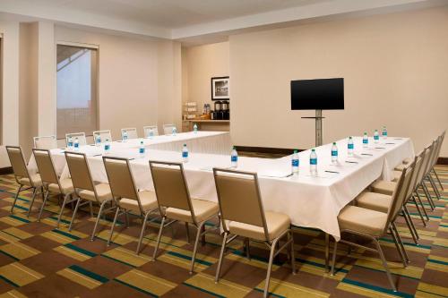 a long table in a room with chairs and a television at Four Points by Sheraton Jacksonville Beachfront in Jacksonville Beach